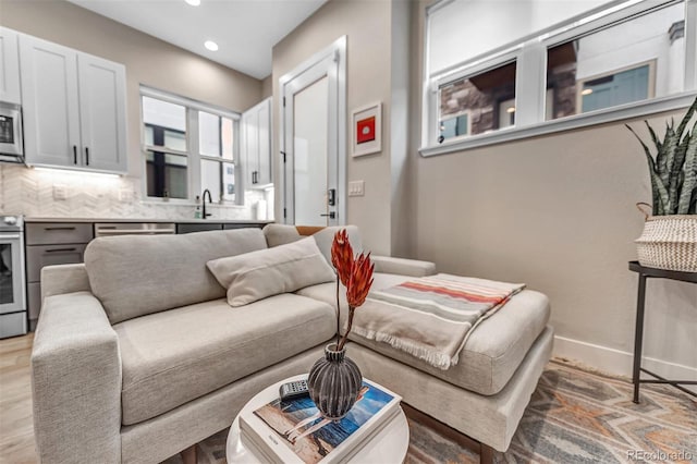 living room with recessed lighting, light wood finished floors, and baseboards