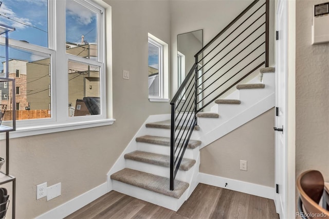 stairs featuring wood finished floors and baseboards