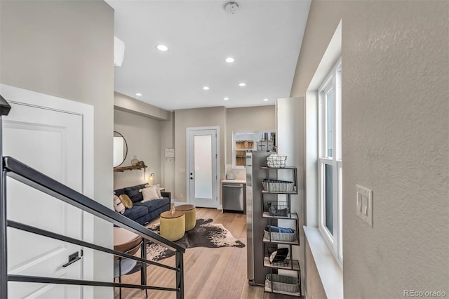 foyer with a textured wall, wood finished floors, and recessed lighting