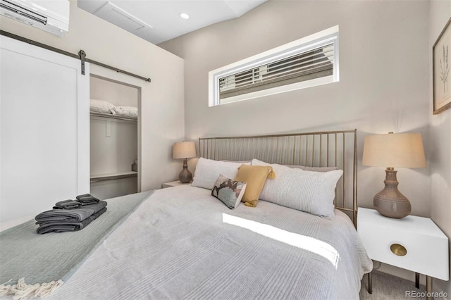 bedroom featuring a barn door, a wall mounted AC, a closet, and recessed lighting