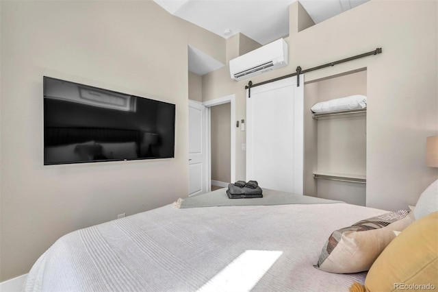 bedroom featuring a barn door, a closet, and a wall mounted air conditioner