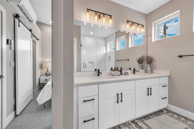 bathroom featuring double vanity, a shower stall, baseboards, and a sink