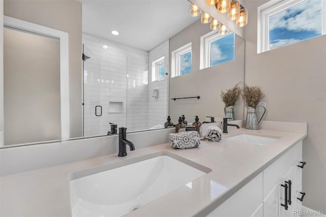 bathroom featuring double vanity, a stall shower, a sink, and recessed lighting