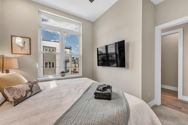 bedroom with baseboards and wood finished floors