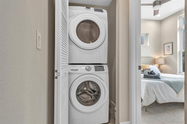 clothes washing area with stacked washing maching and dryer and laundry area