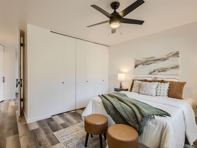 bedroom featuring hardwood / wood-style floors, ceiling fan, and a closet