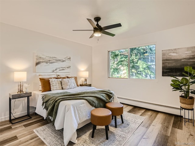 bedroom featuring ceiling fan, a baseboard radiator, and light hardwood / wood-style flooring