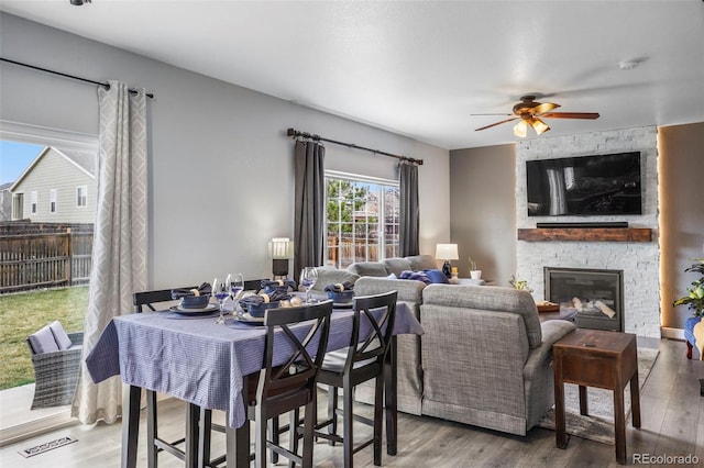 6464 Elsinore Dr, Colorado Springs, CO 80923 - dining space featuring visible vents, a ceiling fan, wood finished floors, and a fireplace