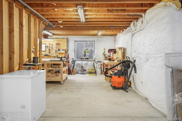 6464 Elsinore Dr, Colorado Springs, CO 80923 - unfinished basement featuring a workshop area and refrigerator