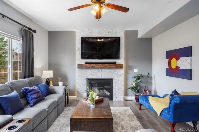 6464 Elsinore Dr, Colorado Springs, CO 80923 - living room with baseboards, a stone fireplace, wood finished floors, and ceiling fan