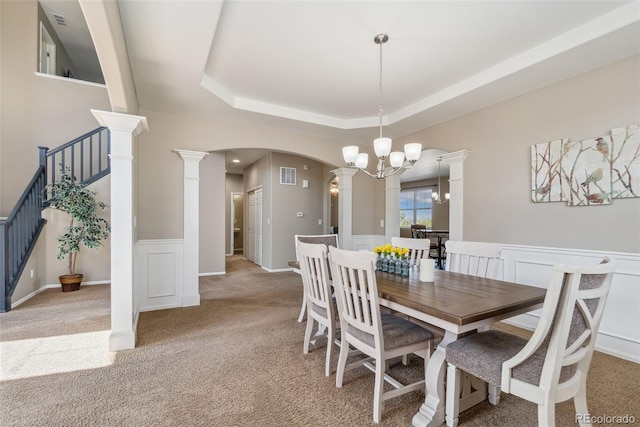 42311 Forest Oaks Dr, Elizabeth, CO 80107 - dining area featuring light carpet, arched walkways, ornate columns, a chandelier, and a tray ceiling