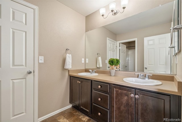 42311 Forest Oaks Dr, Elizabeth, CO 80107 - full bath with double vanity, baseboards, stone finish flooring, and a textured wall
