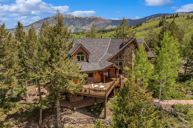 2244 Johnson Rd, Silverthorne, CO 80498 - rear view of house featuring a deck with mountain view, a chimney, and roof with shingles