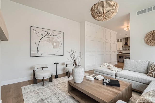 3649 W 21st Ave, Denver, CO 80211 - living area featuring a chandelier, light wood-style floors, and baseboards
