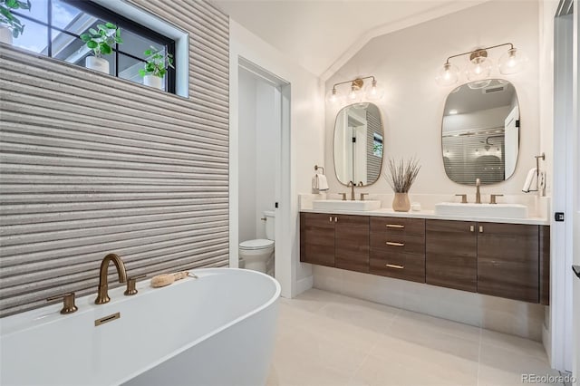 3649 W 21st Ave, Denver, CO 80211 - bathroom featuring a freestanding bath, double vanity, lofted ceiling, tile patterned flooring, and toilet