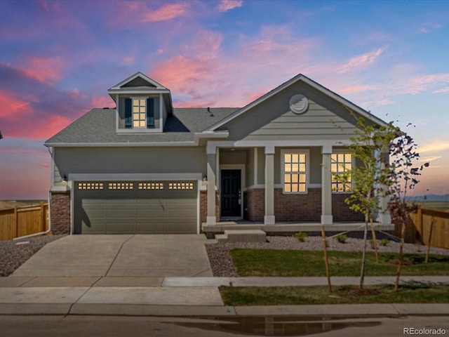9069 Pitkin St, Commerce City, CO 80022 - view of front of house with concrete driveway, covered porch, brick siding, and an attached garage