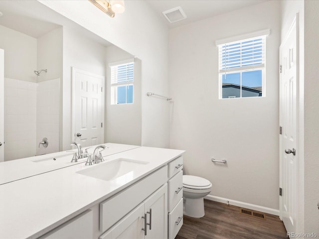 9069 Pitkin St, Commerce City, CO 80022 - bathroom with vanity, toilet, baseboards, wood finished floors, and a shower