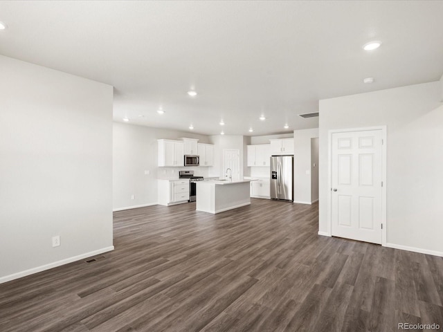 9069 Pitkin St, Commerce City, CO 80022 - unfurnished living room with baseboards, dark wood finished floors, recessed lighting, and a sink