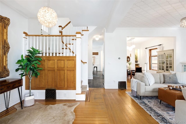 entryway featuring an inviting chandelier, stairs, and wood finished floors