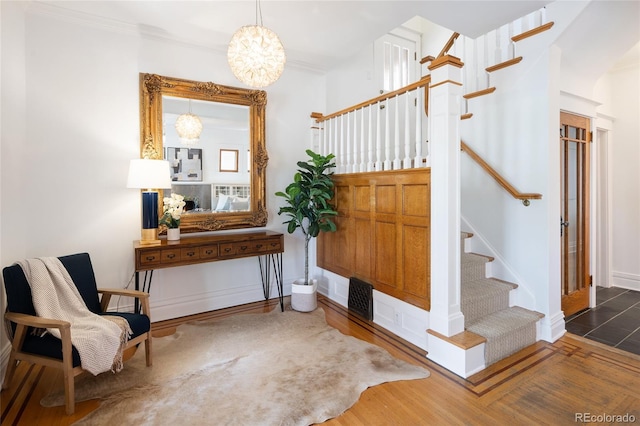 interior space with baseboards, ornamental molding, wood finished floors, and stairway