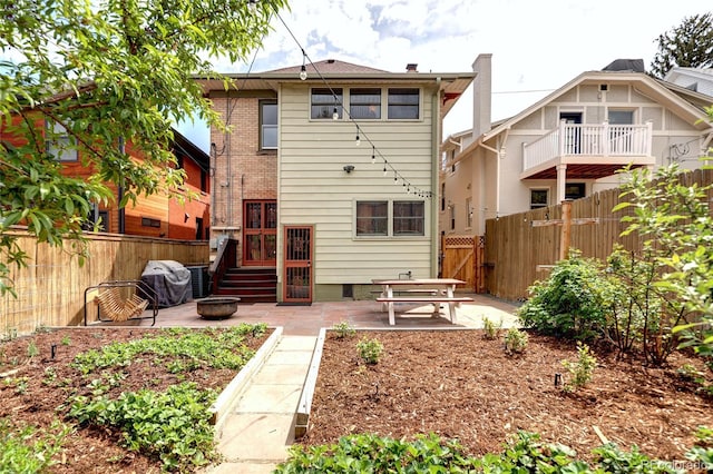back of house with fence, a patio, and crawl space