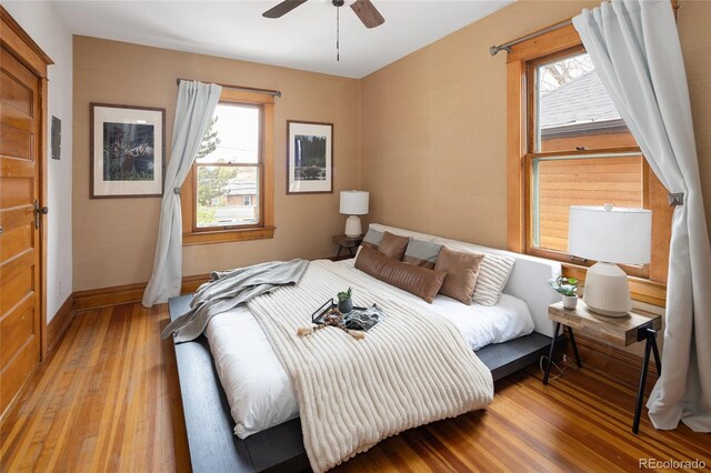 bedroom with baseboards, a ceiling fan, and wood finished floors