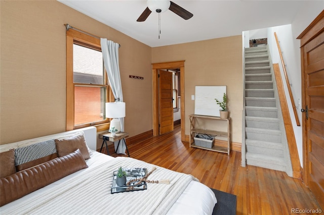 bedroom with baseboards, a ceiling fan, and wood finished floors