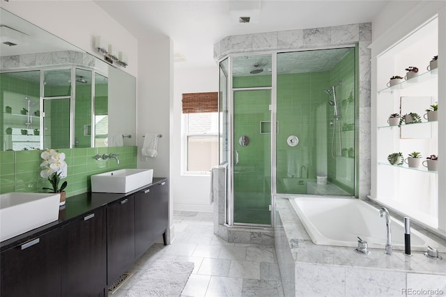 bathroom featuring marble finish floor, a shower stall, a bath, and vanity