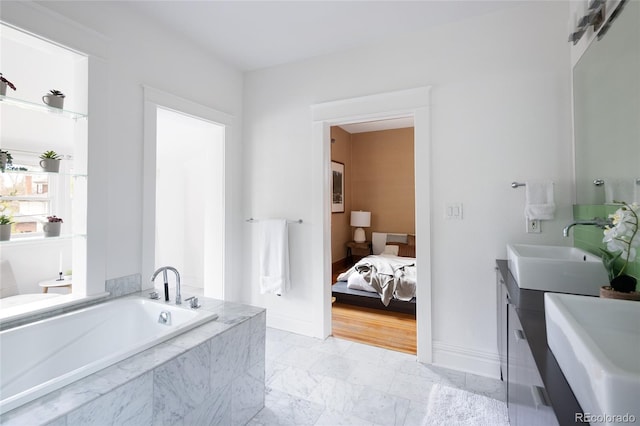 full bath featuring vanity, baseboards, and a garden tub
