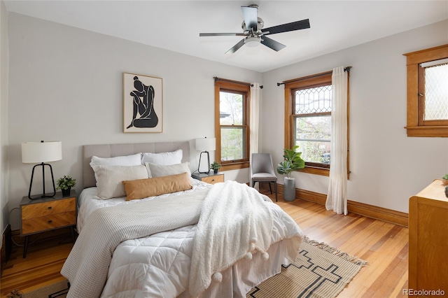 bedroom featuring baseboards, ceiling fan, and light wood-style flooring