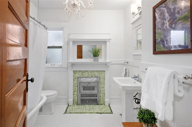 full bathroom featuring tile patterned flooring, an inviting chandelier, a fireplace, toilet, and a shower with curtain