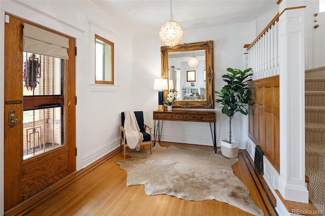 sitting room featuring baseboards, a chandelier, plenty of natural light, and wood finished floors
