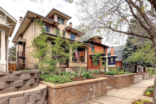 exterior space with brick siding and a chimney