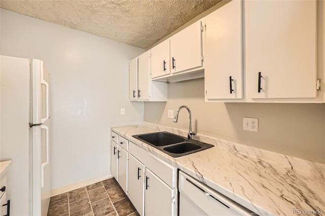 kitchen with a textured ceiling, white appliances, white cabinetry, and sink