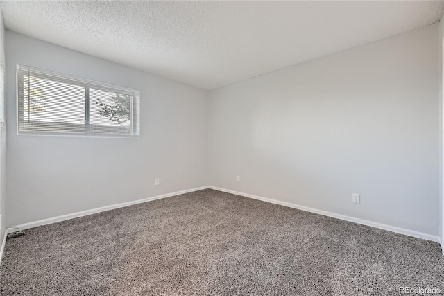 carpeted empty room featuring a textured ceiling