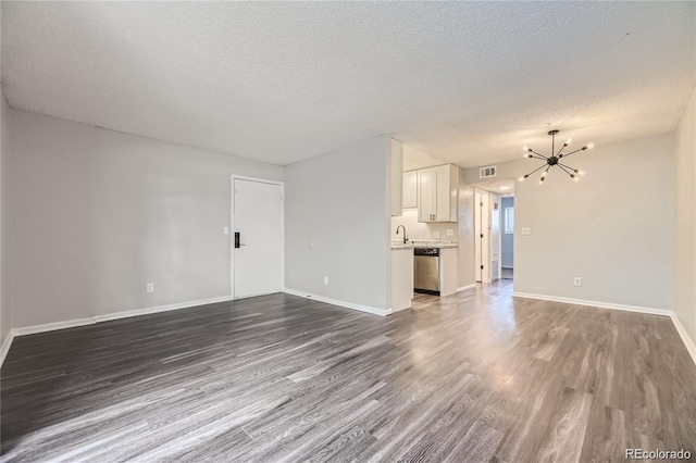 10712 E Exposition Ave Unit 209, Aurora, CO 80012 - unfurnished living room with a chandelier, dark wood-type flooring, a textured ceiling, and baseboards