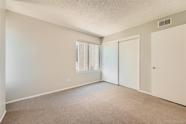 10712 E Exposition Ave Unit 209, Aurora, CO 80012 - unfurnished bedroom featuring a textured ceiling, carpet flooring, a closet, and baseboards