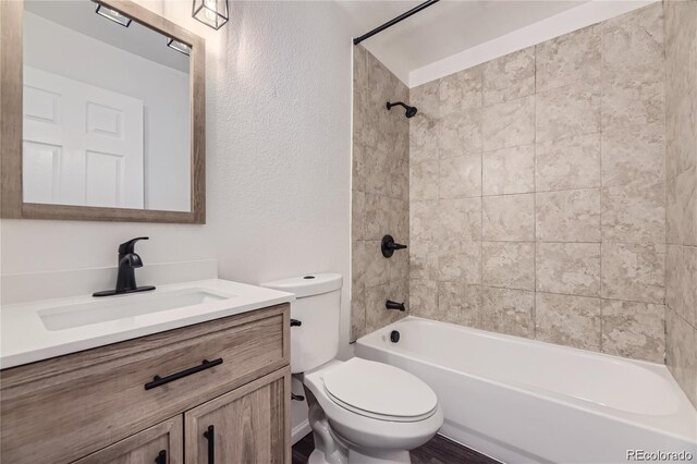 10712 E Exposition Ave Unit 209, Aurora, CO 80012 - bathroom featuring toilet, vanity, shower / bathtub combination, and a textured wall
