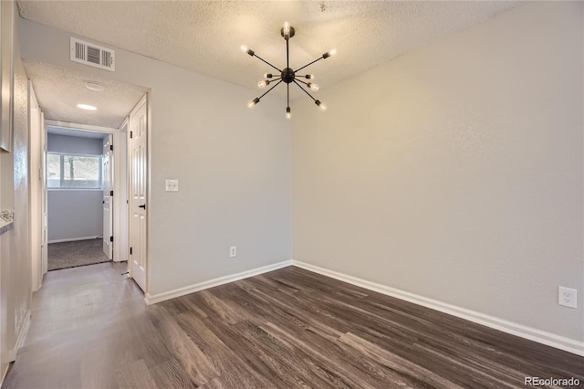 10712 E Exposition Ave Unit 209, Aurora, CO 80012 - unfurnished dining area with dark wood-type flooring, a textured ceiling, a chandelier, and baseboards