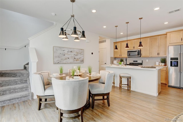 2463 Alpine St, Longmont, CO 80504 - dining area with light wood finished floors, stairway, a chandelier, and recessed lighting