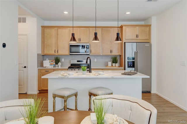 2463 Alpine St, Longmont, CO 80504 - kitchen with stainless steel appliances, light brown cabinets, light countertops, light wood-style floors, and recessed lighting