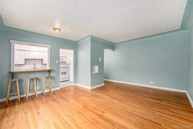 665 Washington St Unit 5B, Denver, CO 80203 - unfurnished living room featuring a sink and light wood-type flooring