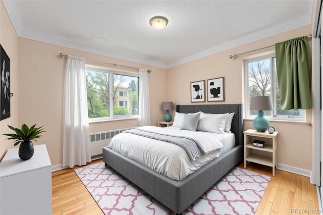 665 Washington St Unit 5B, Denver, CO 80203 - bedroom with radiator heating unit, multiple windows, and light wood finished floors