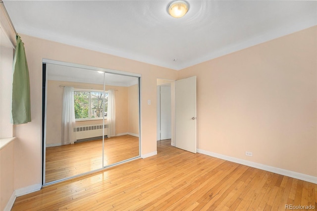 665 Washington St Unit 5B, Denver, CO 80203 - unfurnished bedroom featuring radiator, a closet, and light wood-style flooring