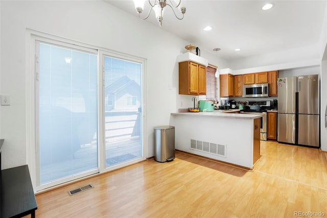 7520 W Coal Mine Ave Unit C, Littleton, CO 80123 - kitchen with stainless steel appliances, plenty of natural light, a peninsula, light wood-style floors, and recessed lighting