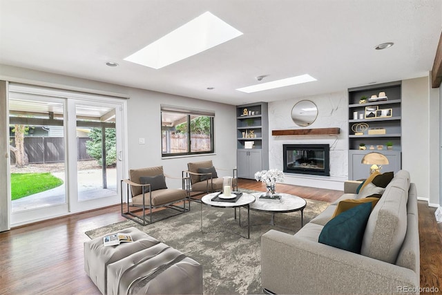 6330 E Vassar Ave, Denver, CO 80222 - living area with a skylight, built in shelves, wood finished floors, and recessed lighting
