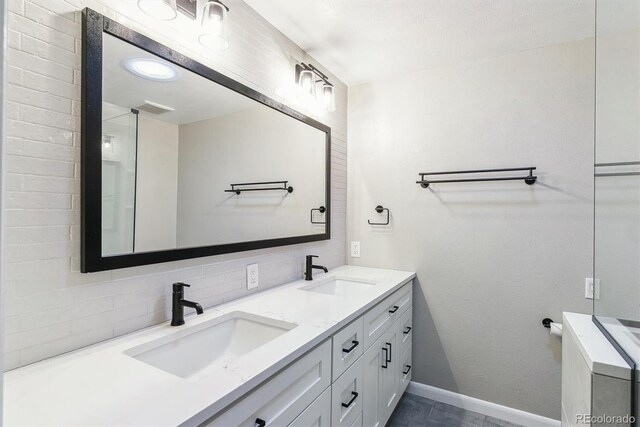 6330 E Vassar Ave, Denver, CO 80222 - bathroom featuring double vanity and decorative backsplash