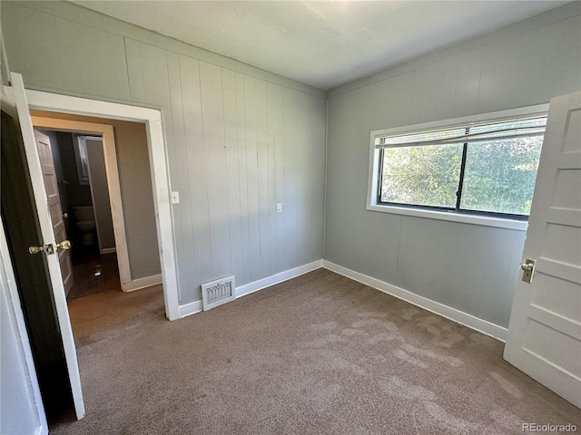 unfurnished room featuring visible vents, carpet flooring, and baseboards