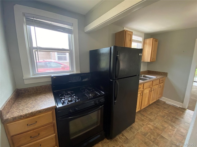 kitchen with light brown cabinetry, visible vents, black appliances, and baseboards