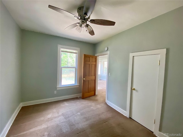 unfurnished bedroom featuring a ceiling fan, baseboards, and carpet floors